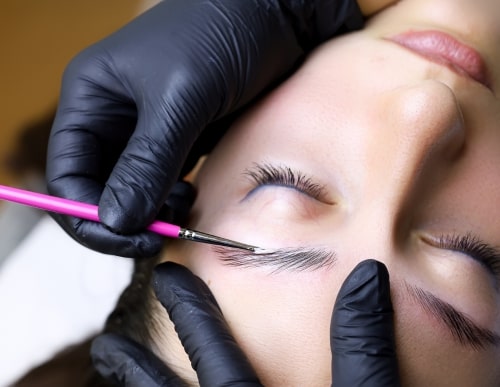 woman receiving lamination eyebrow treatment