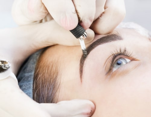 woman receiving microblading eyebrow treatment