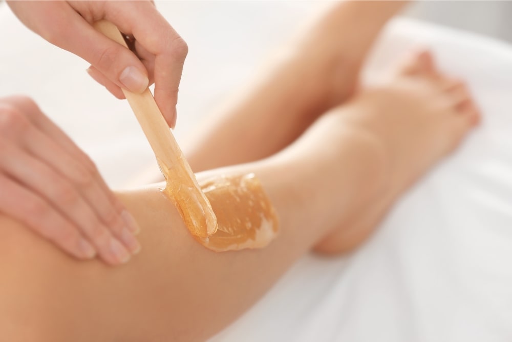 woman applying wax on legs