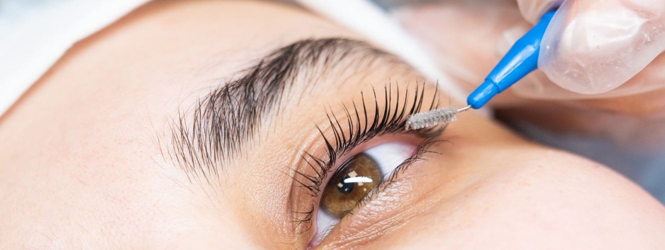 combs the eyelashes of the client