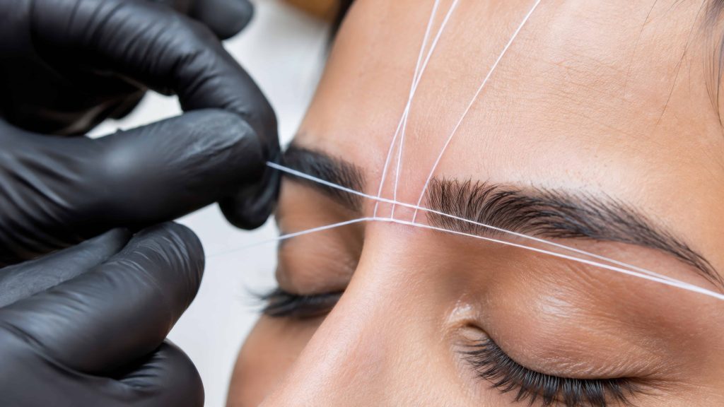 woman threading eyebrow in a professional beauty bar